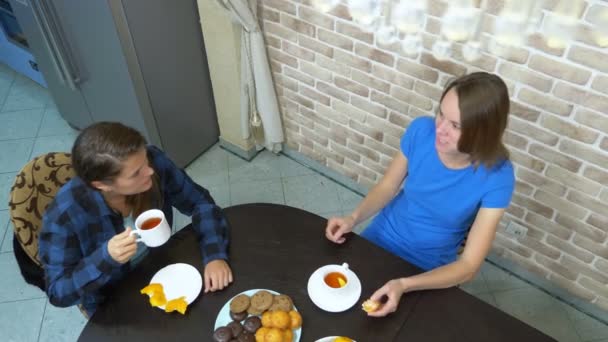 Twee meisjes lesbische drinken thee zitten thuis in de keuken — Stockvideo