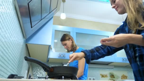 Dwie dziewczyny, lesbijska rodzina przygotowuje jedzenie w kuchni w domu — Wideo stockowe