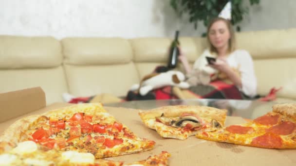 A menina celebra o feriado em casa sozinha. beber, comer pizza e usar o telefone — Vídeo de Stock