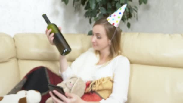 Lonely woman celebrates in the company of soft toys, on the couch, drinks wine — Stock Video