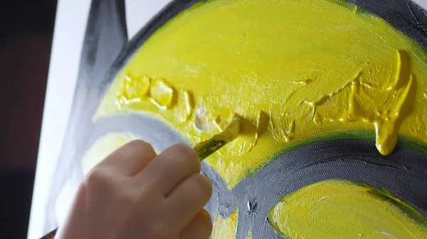 Primer plano. pintura de mano femenina con un pincel sobre lienzo con pinturas al óleo — Foto de Stock