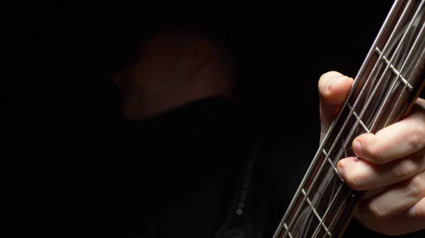 Man plays the bass guitar. Dark background. slowmo — Stock Photo, Image