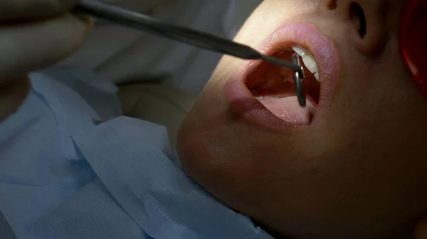 Zbliżenie. Kobieta odwiedza dentystę. ręce dentysty w rękawiczkach. — Zdjęcie stockowe