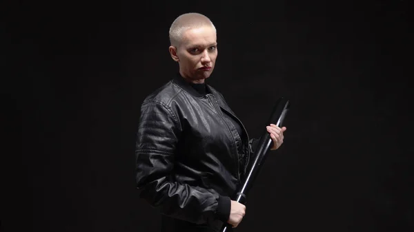 Short haired blond woman in a black leather jacket with a baseball bat — Stock Photo, Image