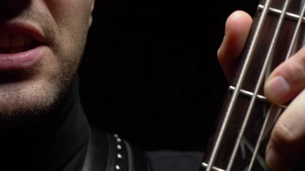Cara masculina y diapasón de guitarra eléctrica sobre fondo negro . —  Fotos de Stock