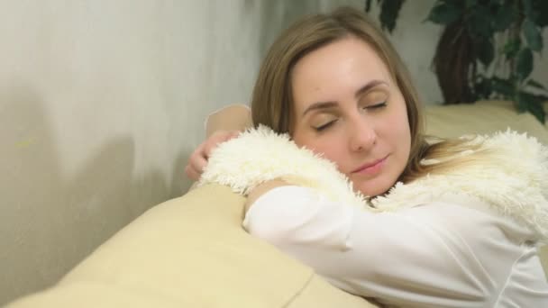 Retrato de una linda rubia. disfrutando de la suavidad de la bufanda mullida blanca — Vídeo de stock