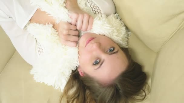 Porträtt av en söt blondin. njuta av mjukheten i vit fluffig halsduk — Stockvideo