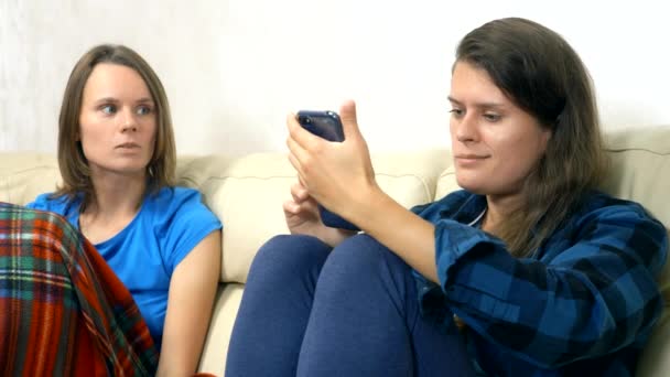 Семейная лесбийская пара разговаривает вместе, сидя дома на диване — стоковое видео