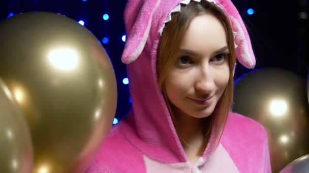 Menina de pijama kigurumi rosa com balões. festa de pijama — Vídeo de Stock