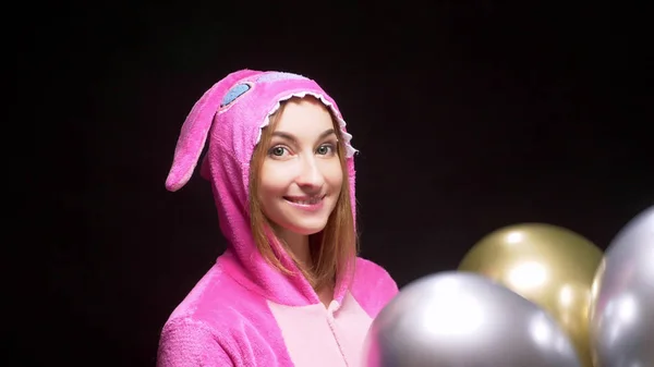 Mädchen in rosa Kigurumi-Pyjamas mit Luftballons. Pyjama-Party — Stockfoto