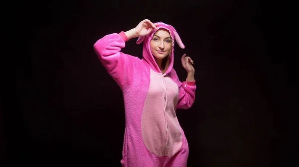 Drôle fille en combinaison kigurumi danse sur un fond noir — Photo