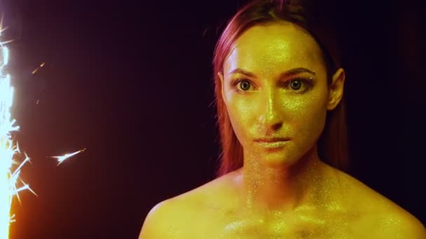Ritratto di una ragazza con brillantini sul viso tra le scintille — Video Stock