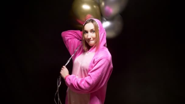 Menina de pijama kigurumi rosa com balões. festa de pijama — Vídeo de Stock