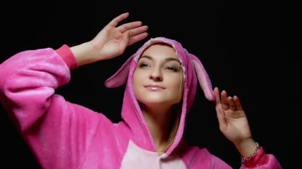 Lustiges Mädchen im Overall kigurumi tanzt auf schwarzem Hintergrund — Stockvideo