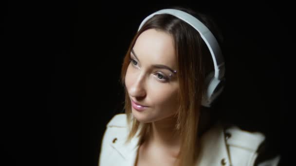 Jolie fille en casque blanc et une veste en cuir blanc sur fond noir — Video