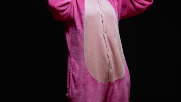 Дівчина в рожевій піжамі Кігурумі в окулярах VR на чорному тлі. піжамна вечірка — стокове відео