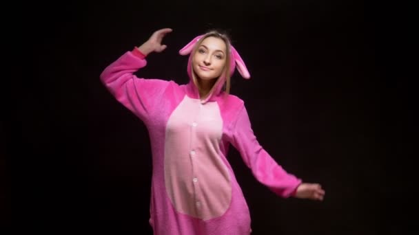 Lány rózsaszín pizsamában kigurumi Vr szemüvegben, fekete háttérrel. pizsamaparti — Stock videók