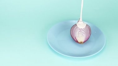 Modaya uygun yemek tasarımı. Soğanın yarısı böğürtlenli pembe yoğurtla sulanır.