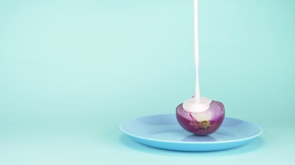 Modisches Lebensmitteldesign. die Hälfte der Zwiebel wird mit beerenrosa Joghurt gegossen — Stockvideo
