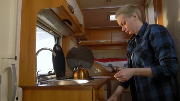 Une femme lave la vaisselle dans un camping-car. concept de voyage en voiture — Video