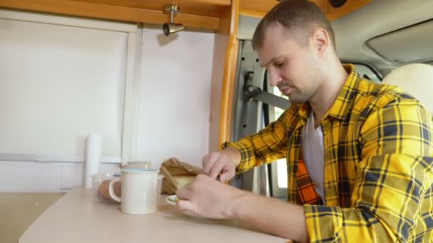 Mamã a comer carne numa mesa numa autocaravana. conceito de viagem de carro — Vídeo de Stock