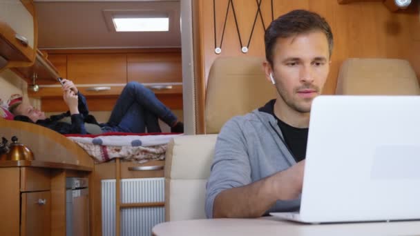 Pareja de hombres y mujeres en la casa del coche. utilizar ordenador portátil y tableta — Vídeos de Stock