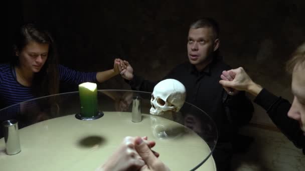 Заседание группы спиритизма людей, сидящих за круглым столом, держащихся за руки — стоковое видео