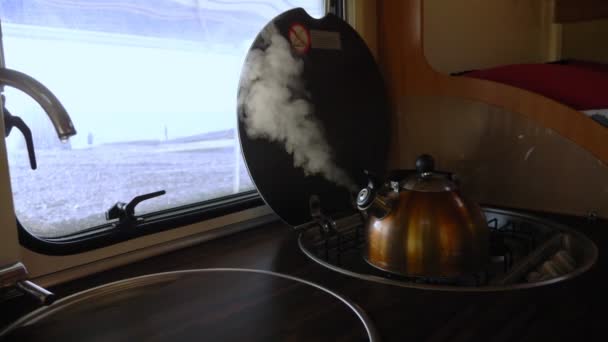 La bouilloire bout sur le poêle dans le camping-car. la vapeur de la bouilloire . — Video