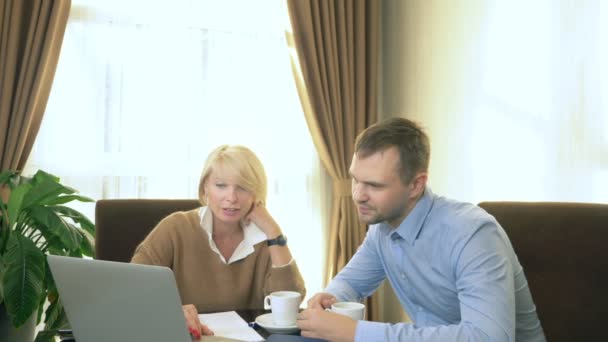 Homem e mulher conversando sentado no escritório na frente do laptop — Vídeo de Stock