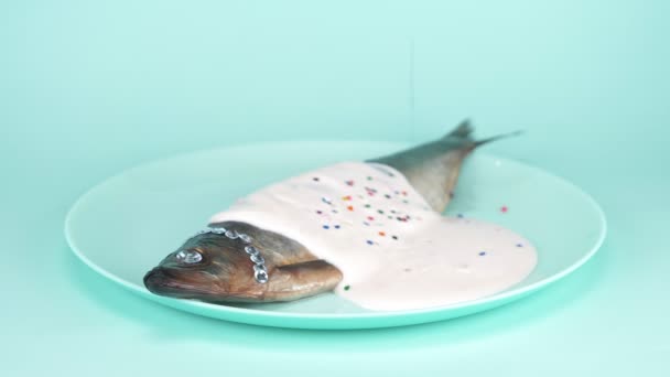 Comida de moda. arenque de pescado con diamantes de imitación, salsa rosa y un colorido confeti — Vídeo de stock