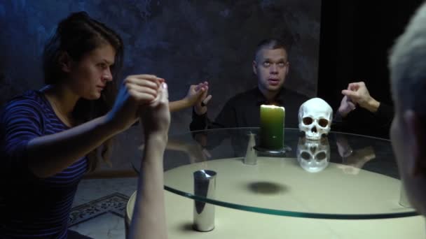 Заседание группы спиритизма людей, сидящих за круглым столом, держащихся за руки — стоковое видео