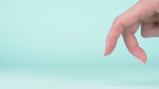 Weibliche Hand Nahaufnahme auf blauem Hintergrund. zwei Finger gehen an der Oberfläche entlang — Stockvideo