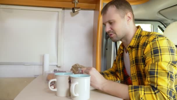 Maman eet vlees aan een tafel in een camper. autotransport — Stockvideo