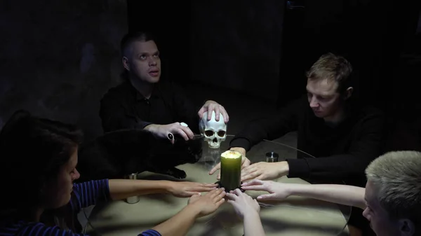 Una sesión de espiritualismo grupo de personas sentadas en una mesa redonda cogidas de la mano —  Fotos de Stock