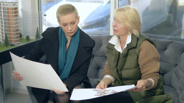 Zwei Frauen reden, während sie in einem Büro vor einem Laptop sitzen — Stockfoto