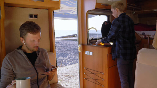 A woman washes dishes in a motorhome. car travel concept