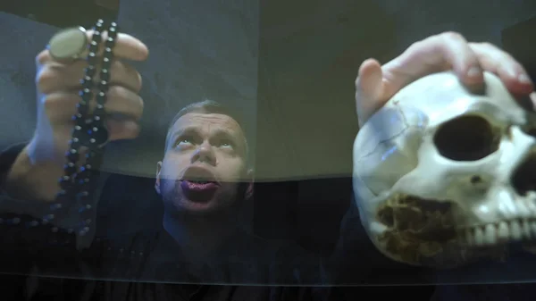 Vista a través de una encimera de vidrio. el mago lanza un hechizo. mano en su cráneo —  Fotos de Stock