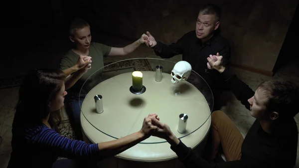 Une séance de spiritualisme groupe de personnes assises à une table ronde se tenant la main — Photo