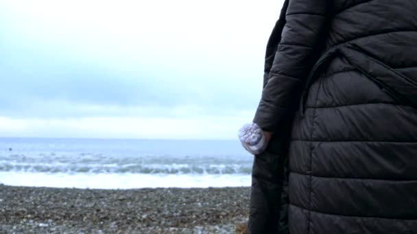 Een close-up. een vrouw gooit een lege plastic fles op het strand. — Stockvideo