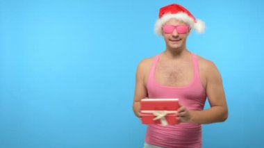 Pembe tişörtlü, şık yeni yıl aksesuarlı, şık pembe gözlüklü, mutlu noeller ve mutlu noeller.
