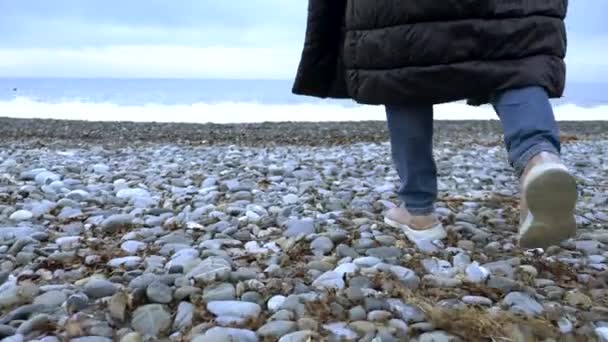 Gros plan. une femme jette une bouteille en plastique vide sur la plage . — Video