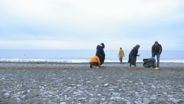 Vrijwilligers ruimen afval op op het strand op in de herfst. milieuvraagstukken — Stockvideo