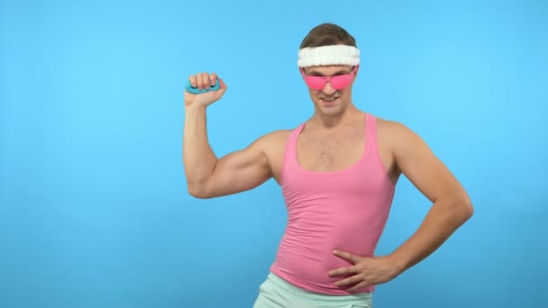 Ein verspielter gutaussehender Mann hält einen manuellen Expander in der Hand. helle Fitness. Sportmodeaccessoires — Stockvideo