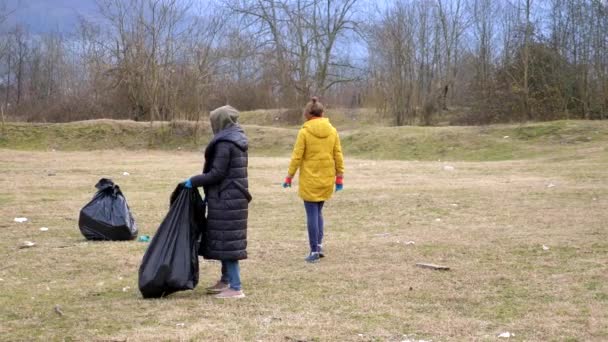 Milieuproblemen. een groep vrijwilligers verwijdert vuilnis in het bos — Stockvideo