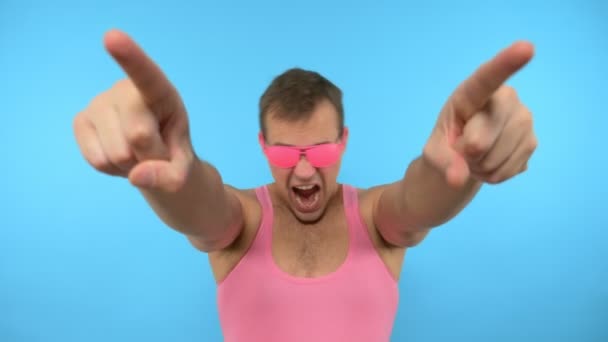 Stylischer Typ mit rosa Brille, der auf blauem Hintergrund tanzt — Stockvideo