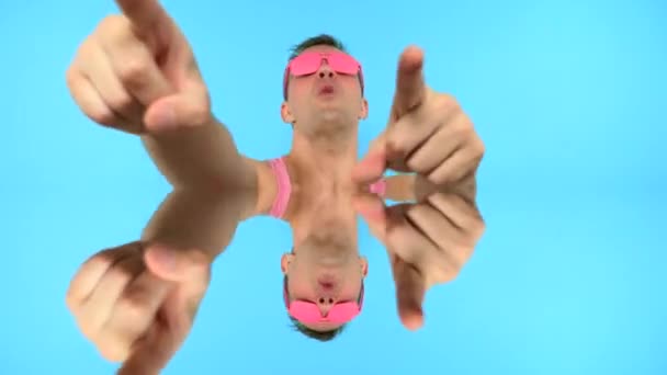Løkke video. kunst GIF design. Stilfuld freak fyr i lyserøde briller. blå baggrund – Stock-video