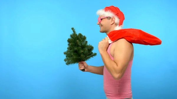 Homem bonito brincalhão em uma camiseta rosa com acessórios elegantes de Ano Novo na moda, em óculos rosa na moda, Feliz Natal e Feliz Ano Novo — Fotografia de Stock