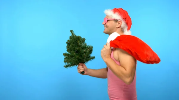 Playful handsome man in a pink T-shirt with fashionable stylish New Year's accessories, in fashionable pink glasses, Merry Christmas and Happy New Year — Stock Photo, Image