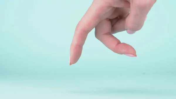 Female hand closeup on blue background. two fingers walk along the surface — Stock Photo, Image