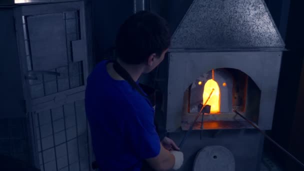 Glasbläser. Hersteller von Glasprodukten. Mann erhitzt Glas im Ofen — Stockvideo